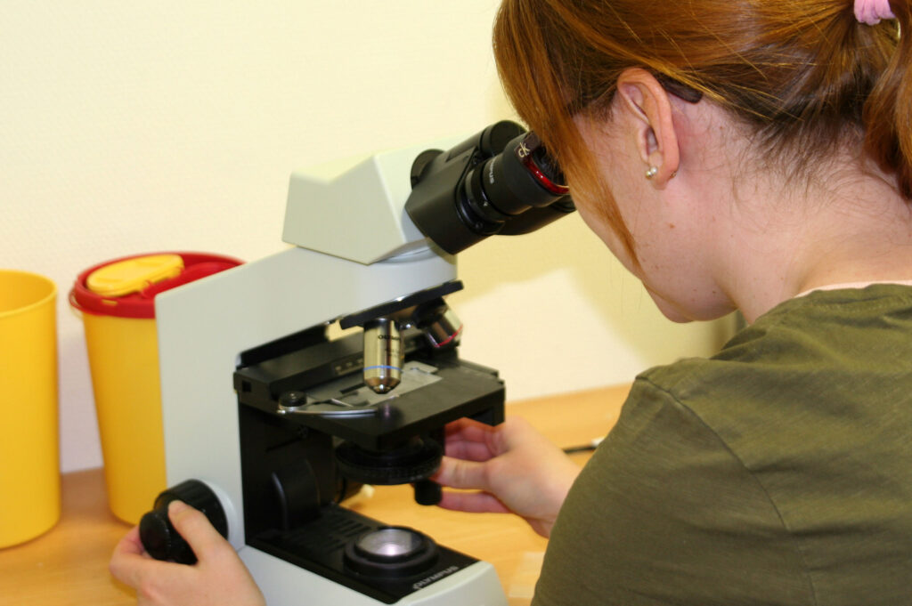 Wissenschaftlerin bei der mikroskopischen Untersuchung